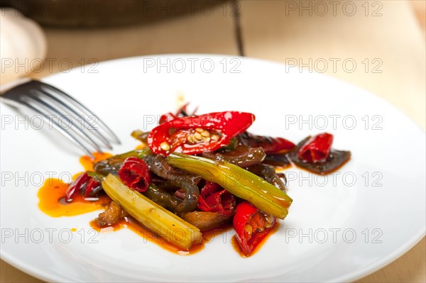 Fried chili pepper and vegetable on a iron wok pan