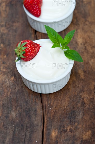 Organic Greek yogurt and strawberry on a rustic wood table