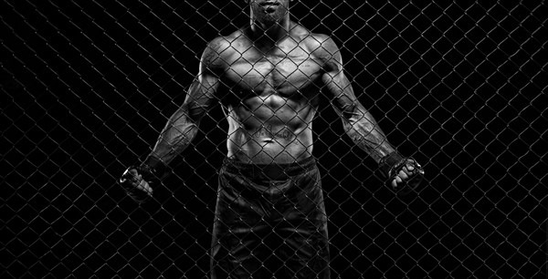 Black and white image of a man in a boxing cage. The concept of sports