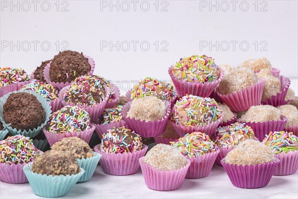 A selection of handmade light and dark rum balls on a white background