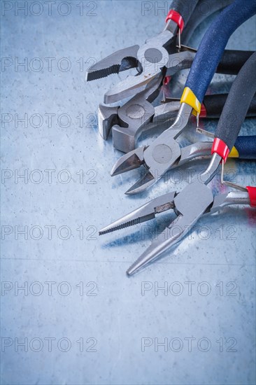 Insulated electric nippers on scratched metallic surface construction concept