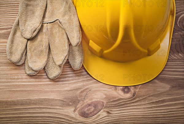 Hard hat leather safety gloves on wood board construction concept