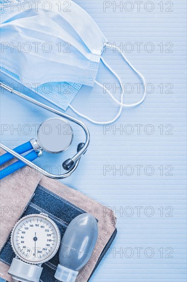 Stethoscope with blood pressure monitor and masks on a blue background medical concept