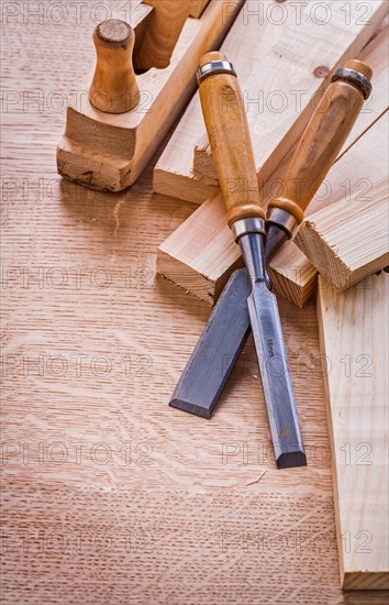 Carpenter's chisel old woodworker's plane and planks on wooden board