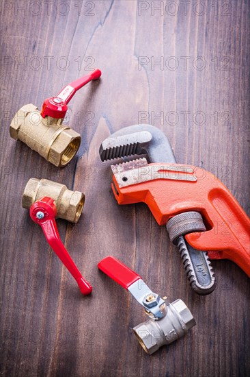 Plumbing accessories and adjustable spanner on an old wooden board