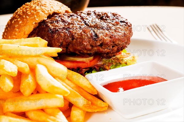 Fresh classic american hamburger sandwich with french fries and ketchup sauce on side