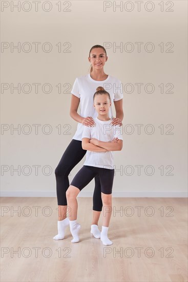 Beautiful female teacher poses with a little girl in a gymnastics class. The concept of education