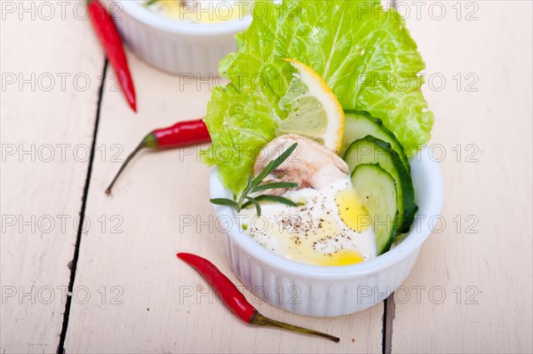 Fresh organic garlic cheese dip salad on a rustic table