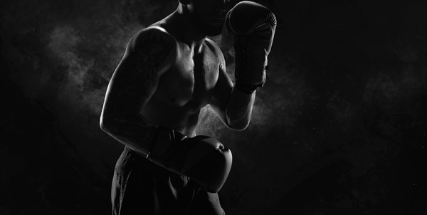 Noname image of a kickboxer on a dark background. The concept of mixed martial arts. MMA