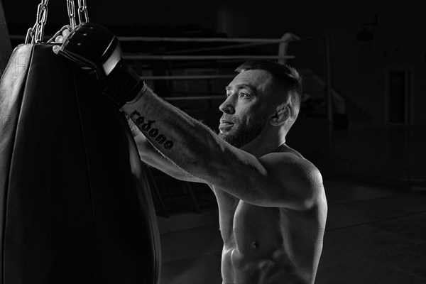 Kickboxer hooks a punching bag to a rope. Sports training. The concept of mixed martial arts. MMA