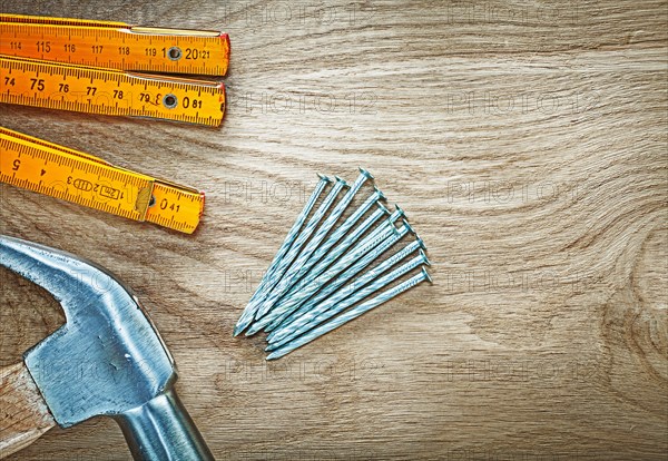 Horizontal image of claw hammer wooden meter construction nails on wood board building concept