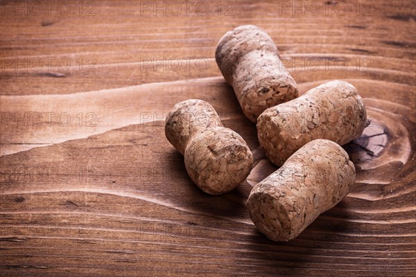 Four corks of champagne on an old wooden board