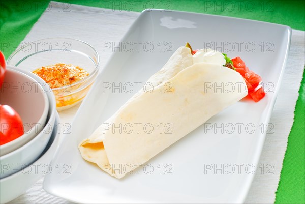 Fresh traditional falafel wrap on pita bread with fresh chopped tomatoes