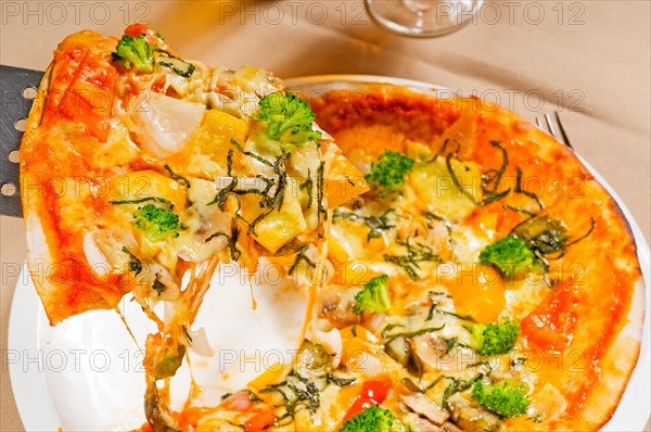 Fresh italian thin style vegetarian pizza with fresh mixed vegetables close up