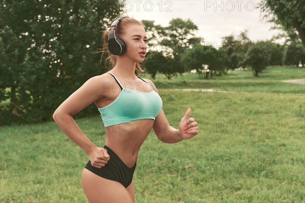 Sports girl jogging in the park. The concept of a healthy lifestyle. Sports Equipment. Fitness style advertisement. Mixed media