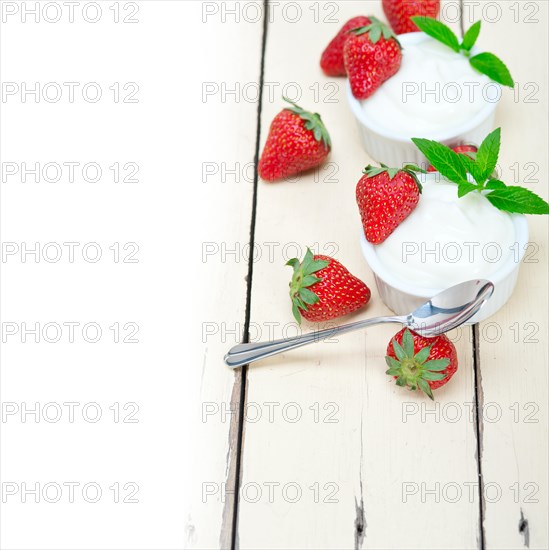 Organic Greek yogurt and strawberry over white rustic wood table