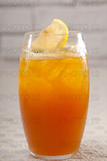 Refreshing Ice tea closeup macro with lemon and mint leaves