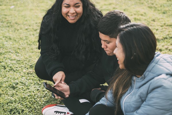 Beautiful latin family laughing from watching smartphone videos