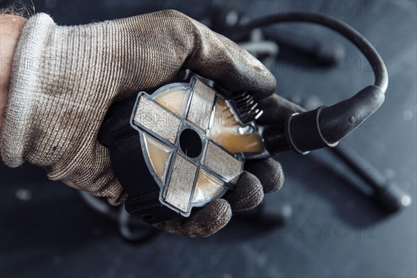 Engine ignition coil in hand of auto mechanic