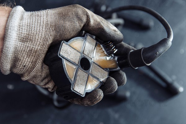 Engine ignition coil in hand of auto mechanic