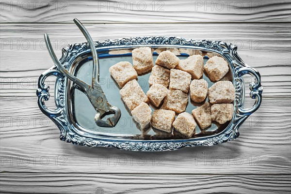 Brown sugar pliers tray on wooden board