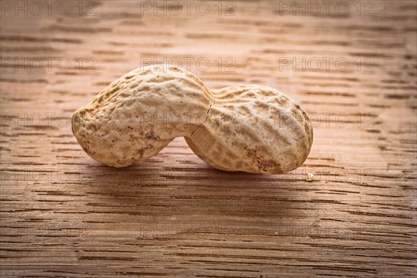 Macroshot single peanut on vintage wooden board food and drink concept