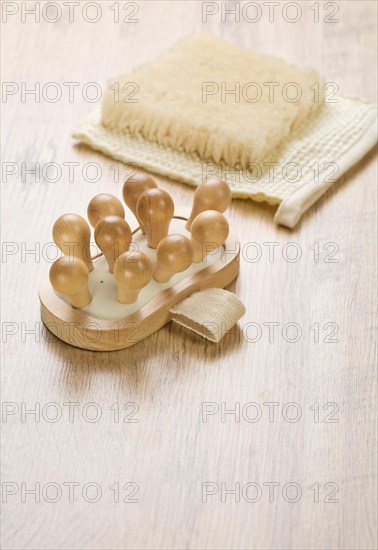 Massager and raffia on a wooden background