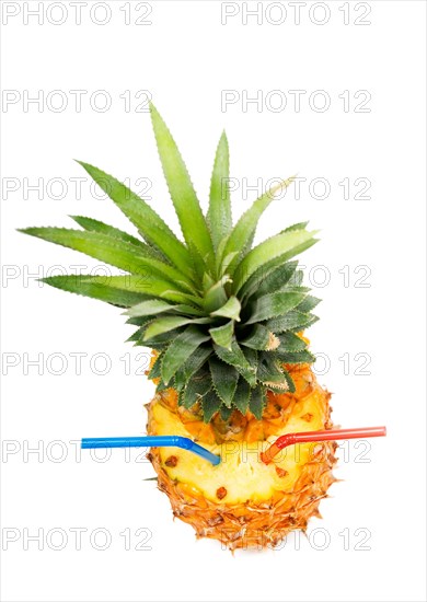 Ripe vivid pineapple with red and blue straw isolated over white background