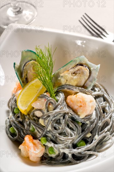 Fresh seafood black squid ink coulored spaghetti pasta tipycal italian food