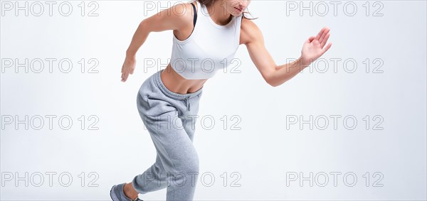 No name portrait. Sports woman runner on a white background. Photo of an attractive woman in fashionable sportswear. Dynamic movement. Side view. Sports and healthy lifestyle. Mixed media