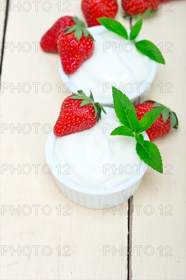 Organic Greek yogurt and strawberry over white rustic wood table