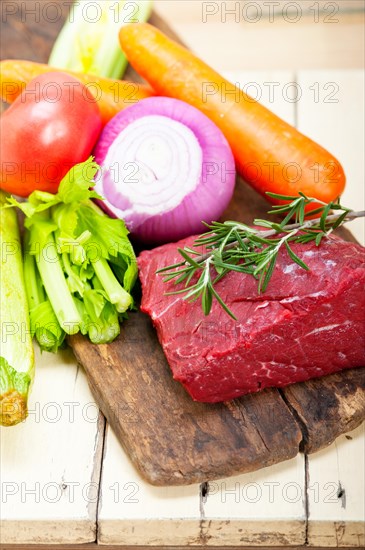 Fresh raw beef cut ready to cook with vegetables and herbs