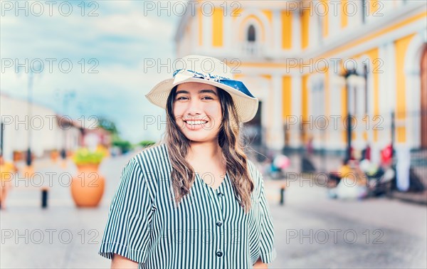 Lifestyle of happy traveler woman in a tourist square. Portrait of smiling tourist woman on the streets of Granada