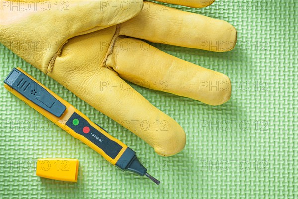 Leather safety glove electrical tester on green background electricity concept