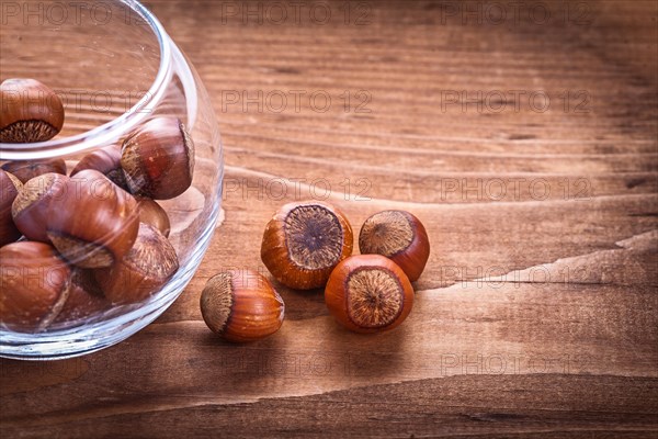 Hazelnuts in a glass and on a vintage wooden board Food and drink concept