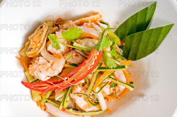 Fresh seafood thai style salad with glass noodles on a bowl close up