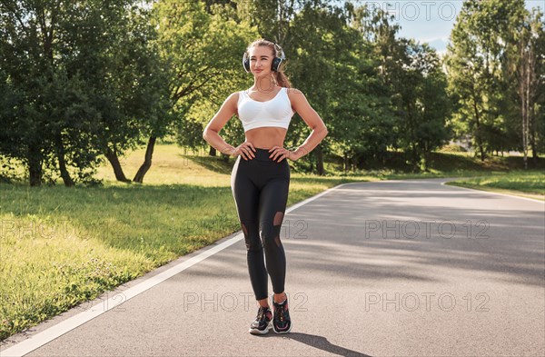 Fitness girl in a white top and black leggings posing on a treadmill. Healthy lifestyle. Morning runs. Mixed media