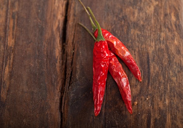 Dry red chili peppers over old wood table