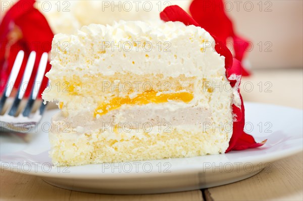 Whipped cream mango cake with red rose petals