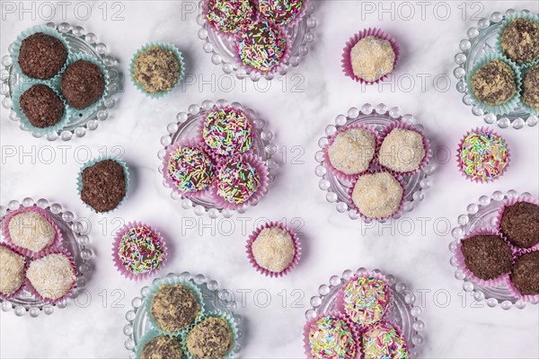 Light and dark rum balls on and next to glass plates