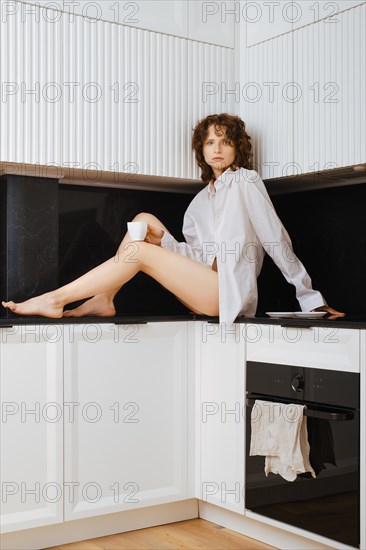 Attractive woman sitting in in profile in a kitchen