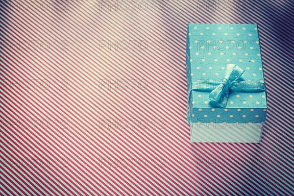 Wrapped present box on red striped textile celebrations concept