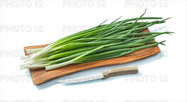 Fresh green onion stems on wooden chopping board and kitchen knife isolated