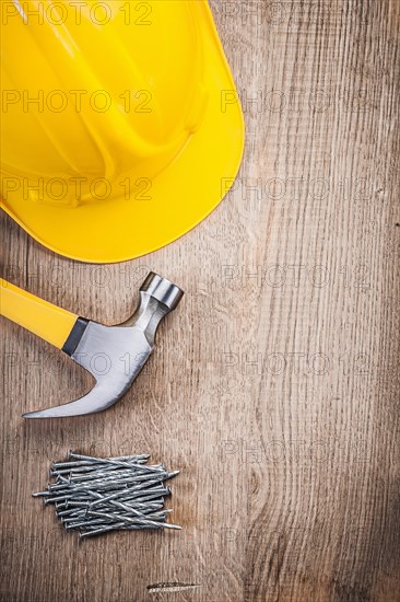 Claw hammer Construction nails Construction helmet on wooden board