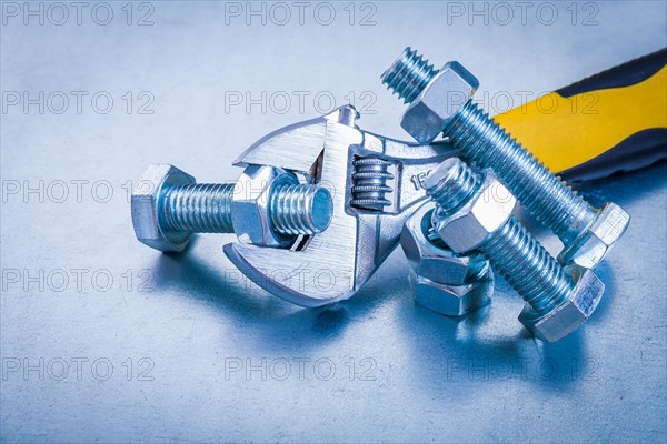 Adjustable tensioner bolt details and screw nuts on metallic background construction concept