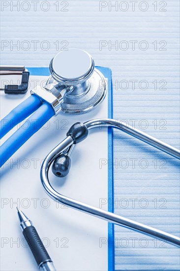Clipboard with white blank paper and stethoscope on blue background medical concept