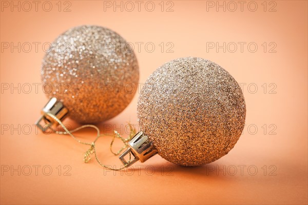 Golden Christmas baubles on a light brown background