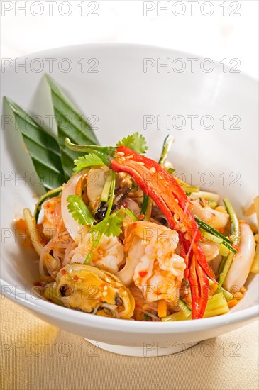 Fresh seafood thai style salad with glass noodles on a bowl close up