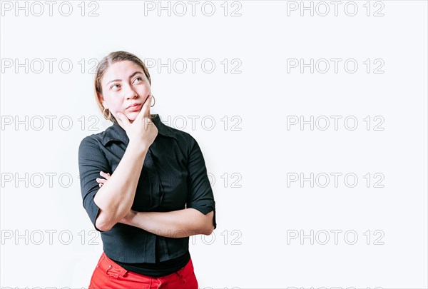 Pensive young woman with hand on chin meditating isolated. Beautiful girl thinking with hand on chin looking up