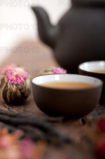 Chinese style herbal floral tea over wood table with raw ingredients